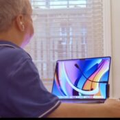 Disabled man in wheelchair dictating at a MacBook laptop with a microphone using Apple voice control