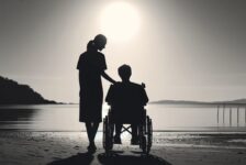Social care carer and person in wheelchair looking out to sea