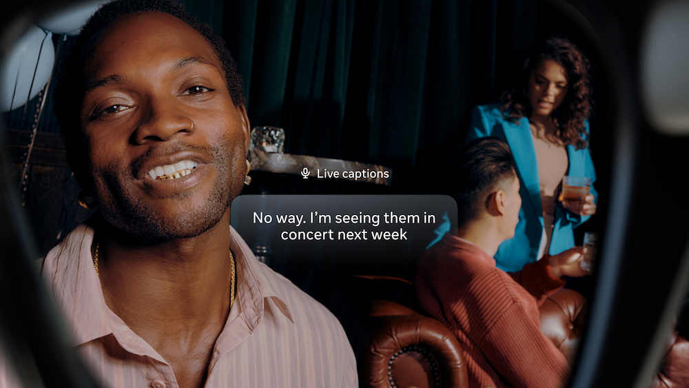 A view from inside the Meta Ray-Ban Display glasses, showing the 'Live captions' accessibility feature transcribing a conversation in real-time as a man in a social setting talks