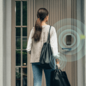 Person approaching a front door with an Aqara smart lock, illustrated with wireless proximity rings to show hands-free unlocking using Ultra Wideband technology.