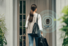 Person approaching a front door with an Aqara smart lock, illustrated with wireless proximity rings to show hands-free unlocking using Ultra Wideband technology.