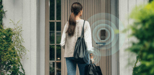 Person approaching a front door with an Aqara smart lock, illustrated with wireless proximity rings to show hands-free unlocking using Ultra Wideband technology.