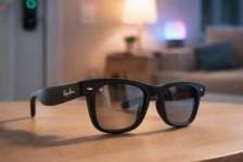 Ray-Ban Meta smart glasses on a wooden table in a modern living room with smart lighting and a smart lock in the background, illustrating smart home control potential.