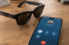 Smart glasses beside a smartphone showing an active call screen with a red end-call button, representing hands-free call controls and accessibility.