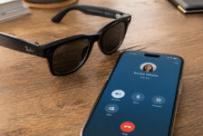 Smart glasses beside a smartphone showing an active call screen with a red end-call button, representing hands-free call controls and accessibility.