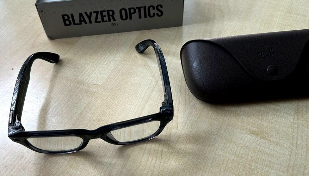 Ray-Ban Meta Blayzer Optics smart glasses on a table with charging case and box for a Ray-Ban Meta Blayzer Optics review.