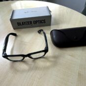Ray-Ban Meta Blayzer Optics smart glasses on a table with charging case and box for a Ray-Ban Meta Blayzer Optics review.