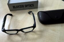Ray-Ban Meta Blayzer Optics smart glasses on a table with charging case and box for a Ray-Ban Meta Blayzer Optics review.
