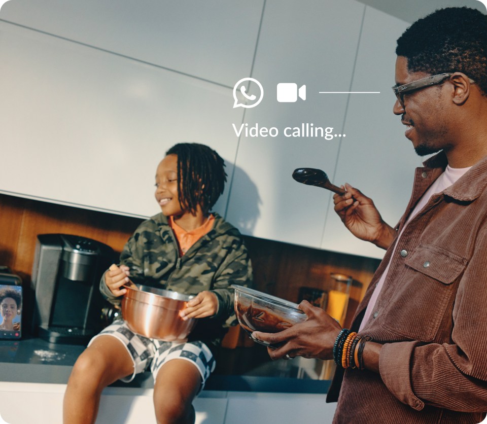 Man wearing Meta smart glasses cooks with a child in a kitchen during a WhatsApp video call.